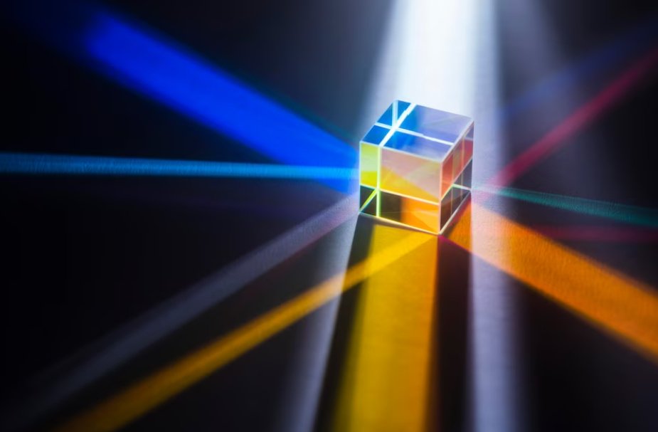 Cubo con riflessi arancioni, rossi, blu, gialli e fasci di luce che partono da esso