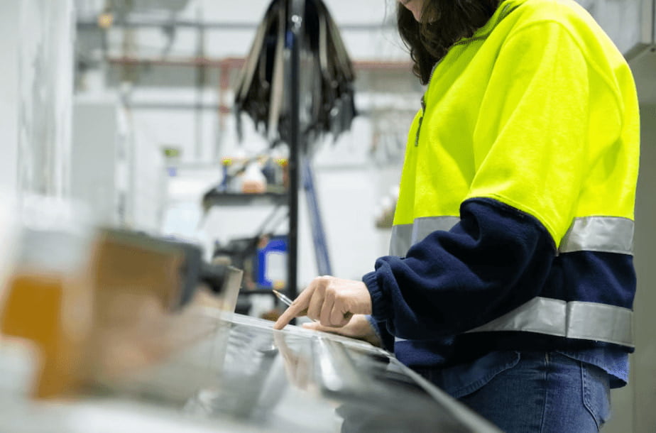 Donna alla dogana vestita con una tuta da lavoro gialla e blu, che controlla i processi