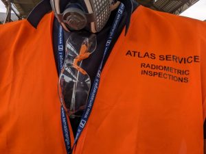 Industrial chemistry and radiation protection: orange safety vest worn by Atlas Radiation Protection staff.